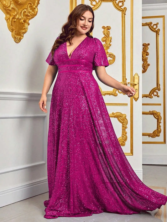 Frau in einem eleganten, pinken Paillettenkleid vor goldverzierter Wand.