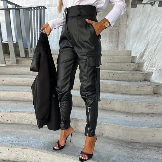 Frau in schwarzer Lederhose und High Heels auf Treppe, modisches Outfit, Business-Look.