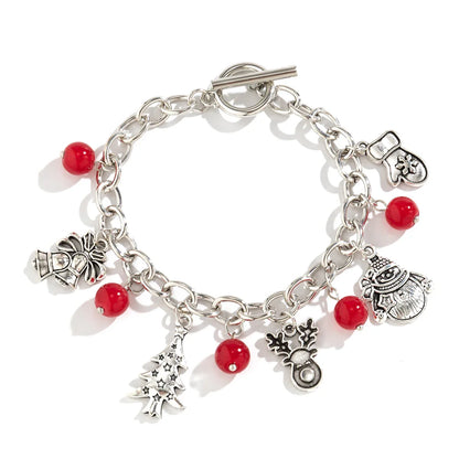 Silbernes Weihnachtsarmband mit roten Perlen und festlichen Anhängern, ideal als Geschenk.