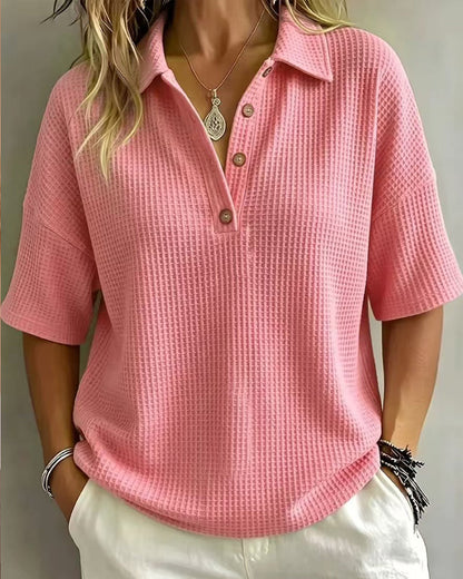 Frontansicht in kräftigem Rosa: lockeres Waffelstrick-Polo mit Kragen und drei Knöpfen am Model 9