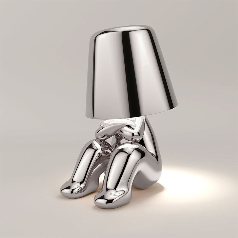 Silberne Tischlampe in menschlicher Form, modernes Design, glänzendes Metall, Wohnzimmerbeleuchtung.