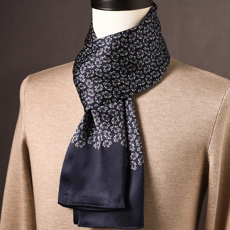 Dunkelblauer Schal mit kleinem Paisleymuster in Weiß und einfarbig blauem Ende, an einer Büste mit beigem Pullover getragen. 26