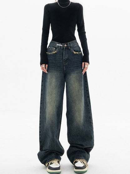 Frau in schwarzem Pullover und weiten Jeans, Streetwear-Mode, lässiger Stil.