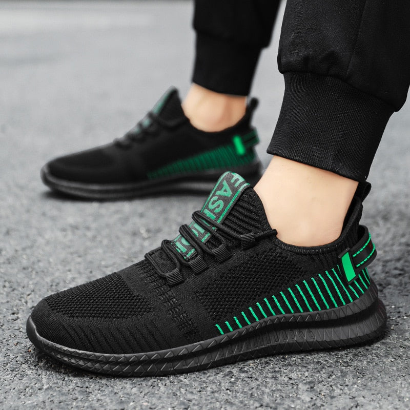 Schwarze Sportschuhe mit grünen Streifen, atmungsaktives Mesh, ideal für Herrenlauftraining.