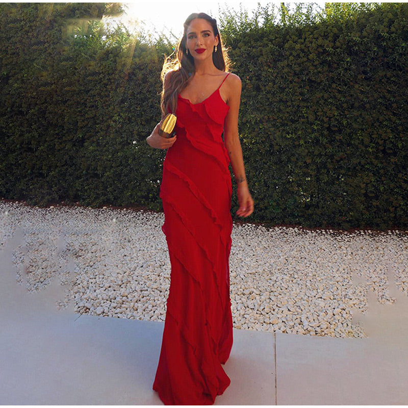 Frau im eleganten roten Abendkleid mit Rüschen, goldene Clutch, draußen, Sonnenuntergang.