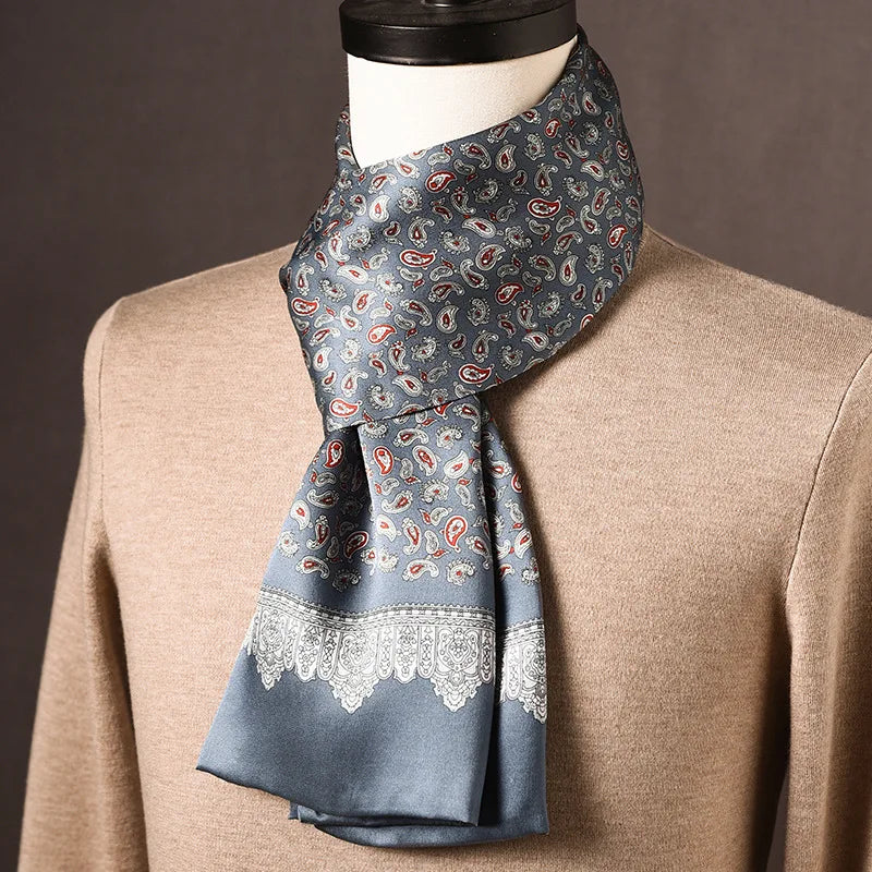 Grau-blauer Seidenschal mit kleinen roten Paisleys und weißer Spitzenbordüre, auf einer Büste mit beigem Pullover. 18