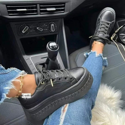 Schwarze Plateau-Sneaker aus Leder, getragen im Auto, modisch, Damen, lässig, bequem.
