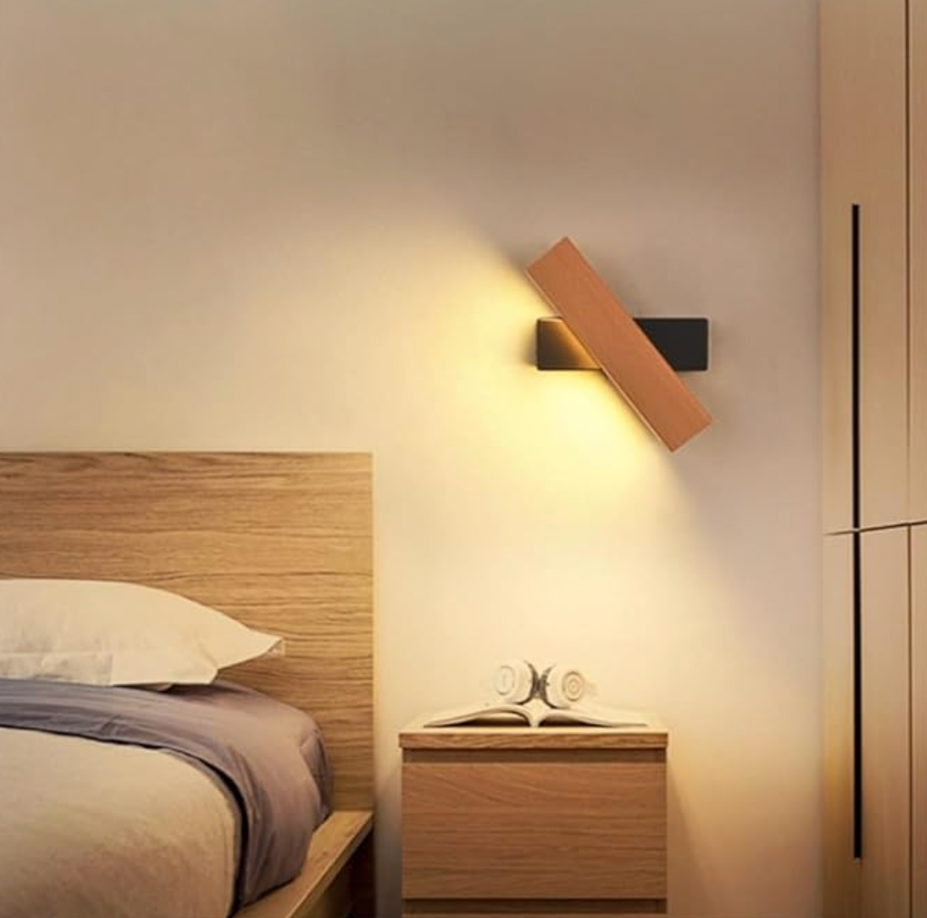 Gedrehte Wandlampe mit schwarzer Halterung über dem Nachttisch im Schlafzimmer neben Holzbett und Kopfhörern. 6