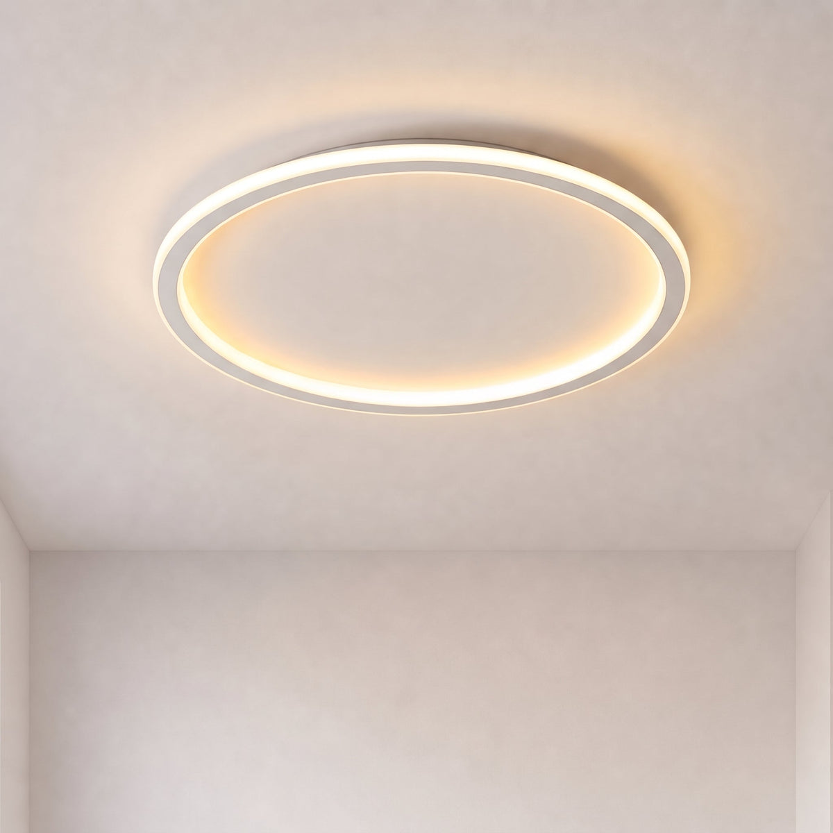 Eingeschaltete runde Deckenleuchte mit leuchtendem Ring, frontal von unten vor schlichter heller Decke und Wand fotografiert. 1