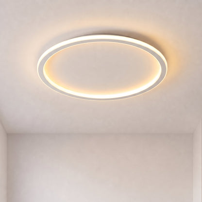 Eingeschaltete runde Deckenleuchte mit leuchtendem Ring, frontal von unten vor schlichter heller Decke und Wand fotografiert. 1