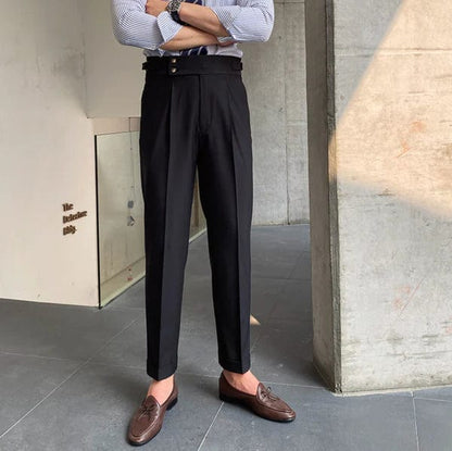 Mann in schwarzer Anzughose, braune Loafer, gestreiftes Hemd, moderne Herrenmode.