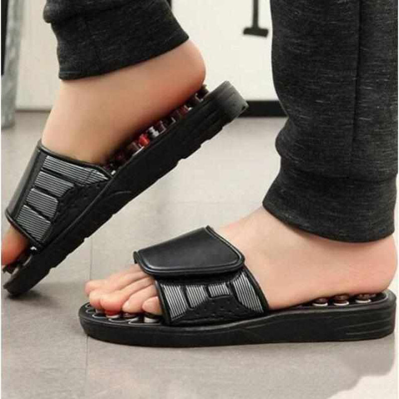 Schwarze Akupressur-Sandalen mit Massagefunktion, getragen von Person, Nahaufnahme.