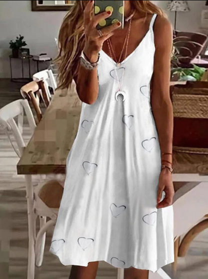 Frau in weißem Sommerkleid mit Herzmuster, V-Ausschnitt, ärmellos, lässig, modisch.