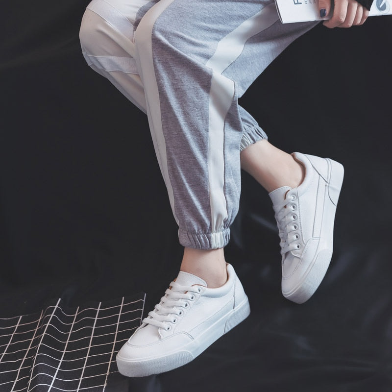 Weiße Sneaker Damen, lässig, modisch, bequem, graue Jogginghose, Freizeitlook.
