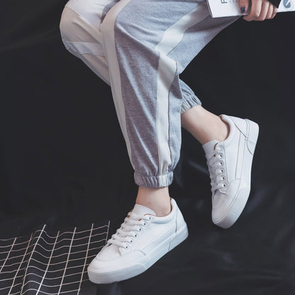 Weiße Sneaker Damen, lässig, modisch, bequem, graue Jogginghose, Freizeitlook.