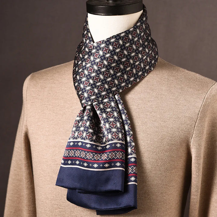 Schal in Marineblau mit sternförmigem Muster in Rot und Weiß und gemusterter Bordüre, um den Hals einer Büste über einem beigen Pullover geschlungen. 21