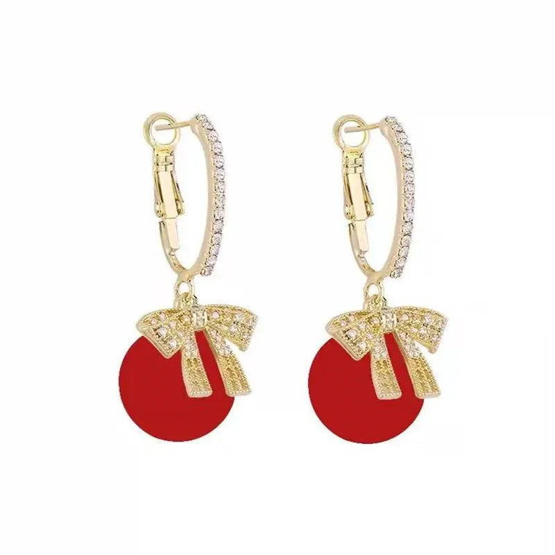 Goldene Ohrringe mit rotem Anhänger und Schleife, Damen Schmuck, elegant, modisch.