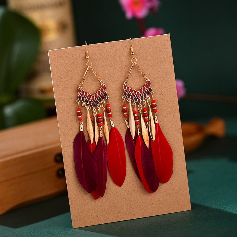 Rote und violette Federohrringe mit goldenen Akzenten, Boho-Stil, handgefertigt.
