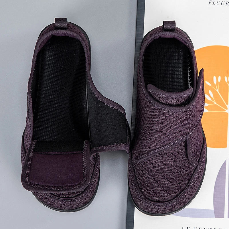 Dunkellila Schuhe von oben, ein Klettverschluss offen, der den weiten Einstieg und die schwarze Innensohle zeigt 5