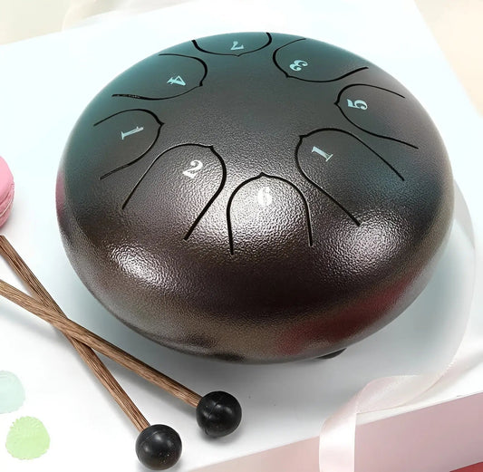 Schwarze Stahlzungentrommel mit Schlägeln, ideal für Meditation und Musiktherapie.