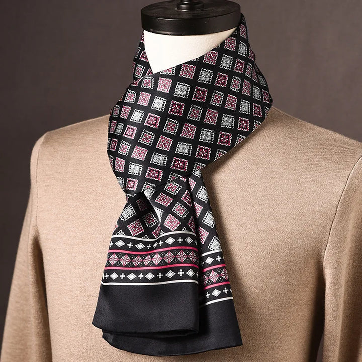 Schwarzer Seidenschal mit rosa-weißem Rautenmuster und schmaler Zierbordüre, auf einer Büste mit beigem Pullover. 15