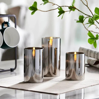 Drei silberne LED-Kerzen auf Tisch, moderne Dekoration, reflektierende Oberfläche, Wohnzimmer.