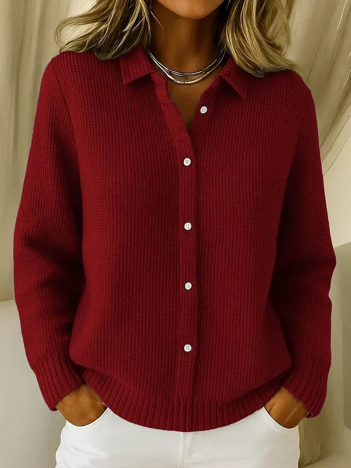 Der Strickpullover in Dunkelrot am Model, Frontansicht mit Kragen, weißen Knöpfen und gerippten Bündchen an Ärmeln und Saum. 3