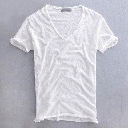 Weißes V-Ausschnitt-T-Shirt mit leicht strukturiertem Stoff, Vorderansicht flach auf grauem Hintergrund, Ärmelsäume lässig umgekrempelt. 2