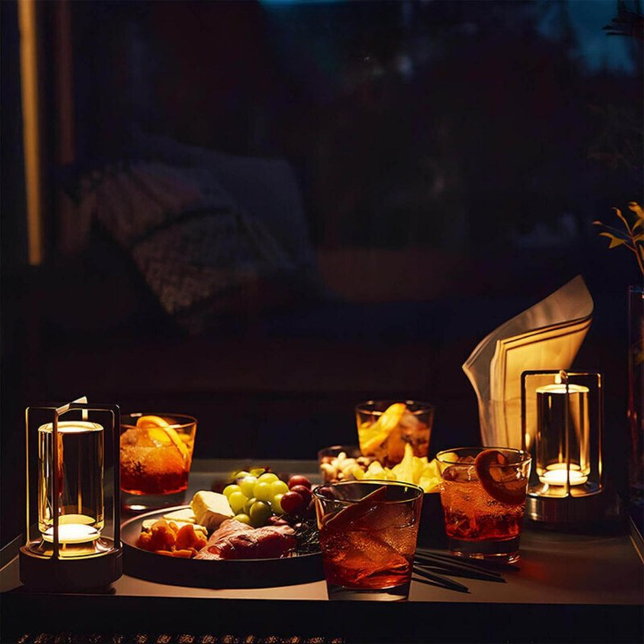 Zwei Tischlampen spenden gedimmtes Licht auf einem Abendtisch mit Cocktails, Käse, Trauben und Aufschnitt. 6