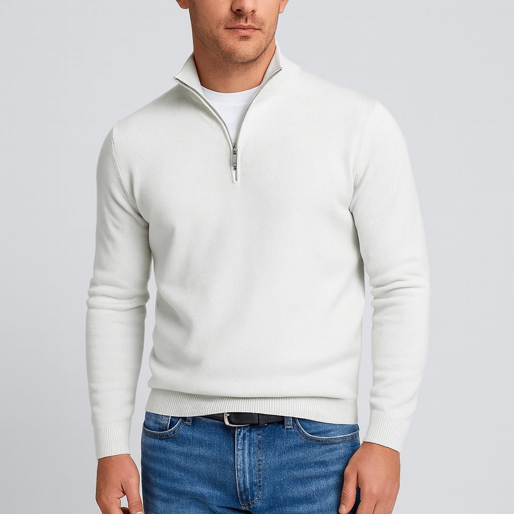 Model trägt den Pullover in Weiß mit Stehkragen und Reißverschluss, dazu Jeans und Ledergürtel 2