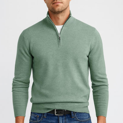 Frontansicht des grünen Pullovers am Model mit Reißverschluss am Kragen, dazu Jeans und Gürtel 12