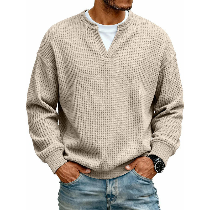 Pullover in Beige mit Waffelstruktur und V-Ausschnitt, getragen über weißem Shirt, Model mit Armbanduhr. 5
