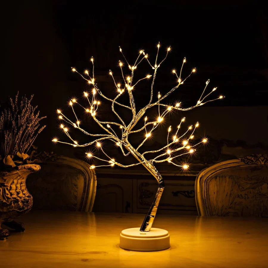 Lichterbaum mit warmweißen Lichtern auf einem Tisch vor dunklem Hintergrund, seitlich Trockenblumen in einer Vase 2