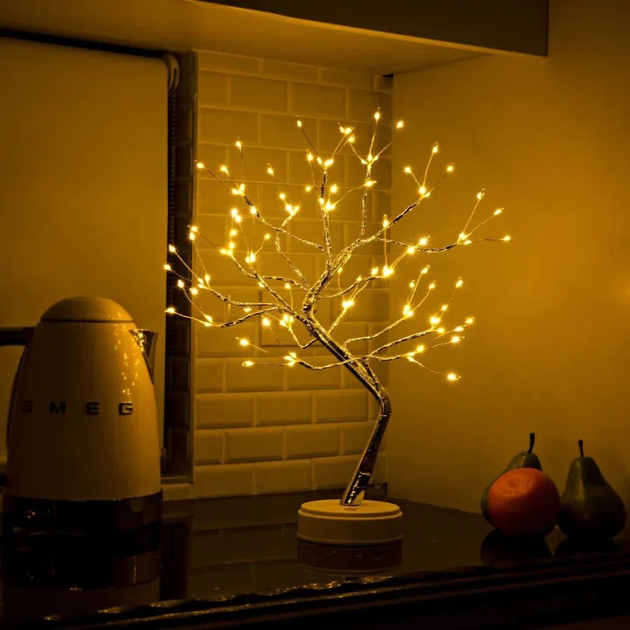 Lichterbaum auf einer Küchenablage vor weißen Fliesen, daneben ein Wasserkocher, eine Orange und Birnen 5