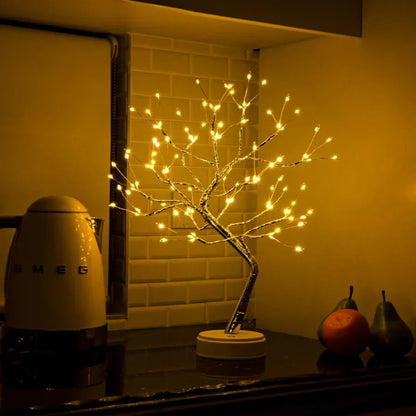 Lichterbaum auf einer Küchenablage vor weißen Fliesen, daneben ein Wasserkocher, eine Orange und Birnen 5