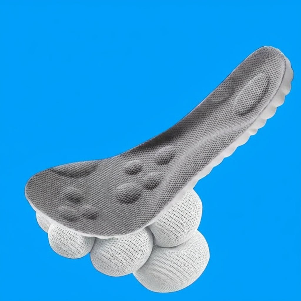 Graue Einlage mit Noppen im Fußbett schwebt schräg über mehreren runden, weichen Kissen, vor einfarbig blauem Hintergrund. 7
