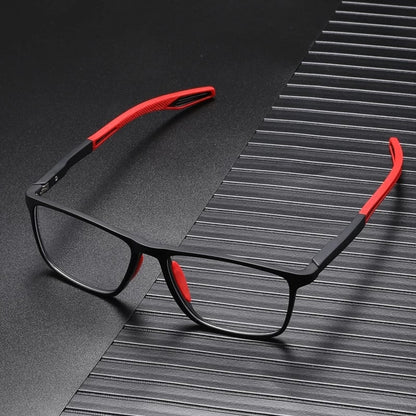 Schwarze Brille mit roten Bügelenden und roten Nasenpads, auf dunkler gerillter Unterlage liegend 3