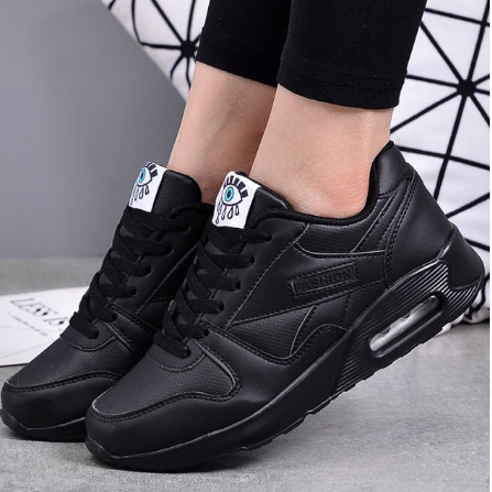 Komplett schwarze Sneaker mit Luftpolster-Sohle, von einem Model zu schwarzer Leggings getragen 2