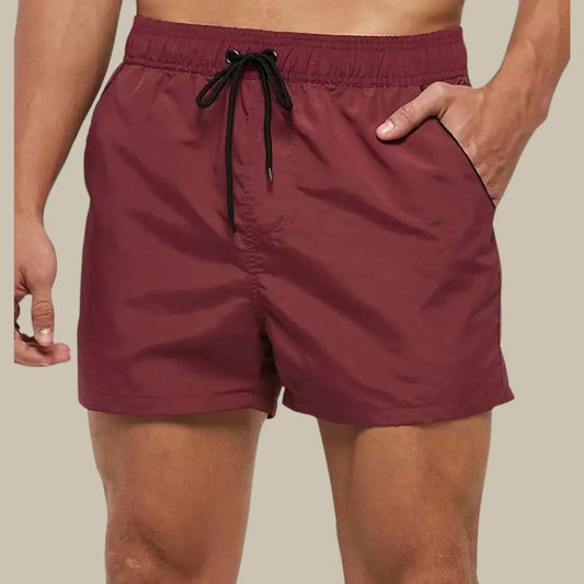 Rote Herren-Badeshorts mit Kordelzug, elastischer Bund, seitliche Taschen.