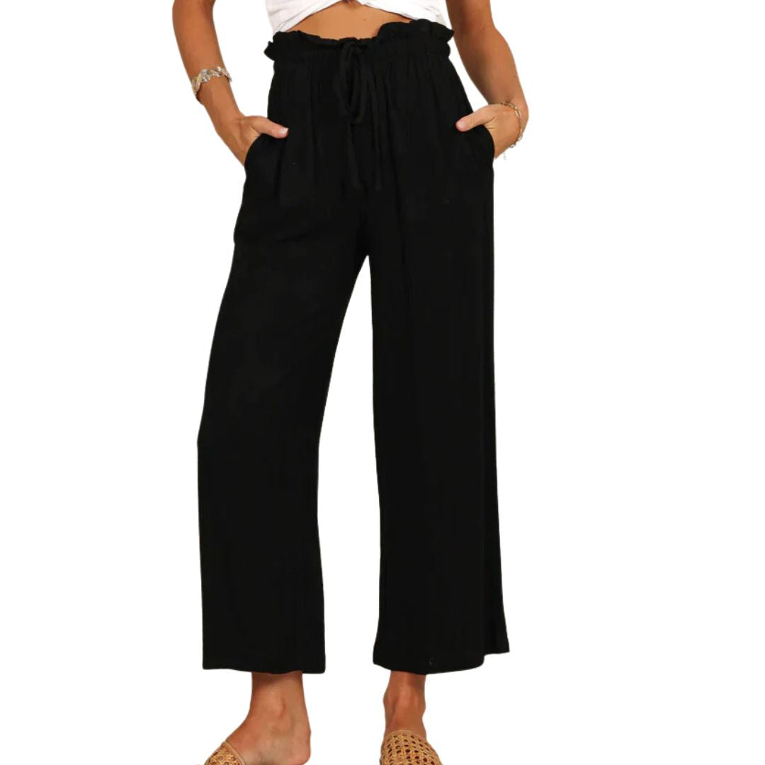 Frau in schwarzer, weiter Hose mit Kordelzug, lässiger Sommerlook, Mode für Damen.