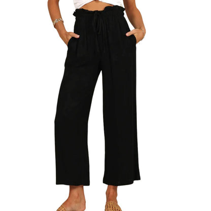 Frau in schwarzer, weiter Hose mit Kordelzug, lässiger Sommerlook, Mode für Damen.