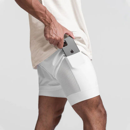 Mann in weißen Sportshorts mit Smartphone in der Tasche, Fitnessbekleidung, Herrenmode.