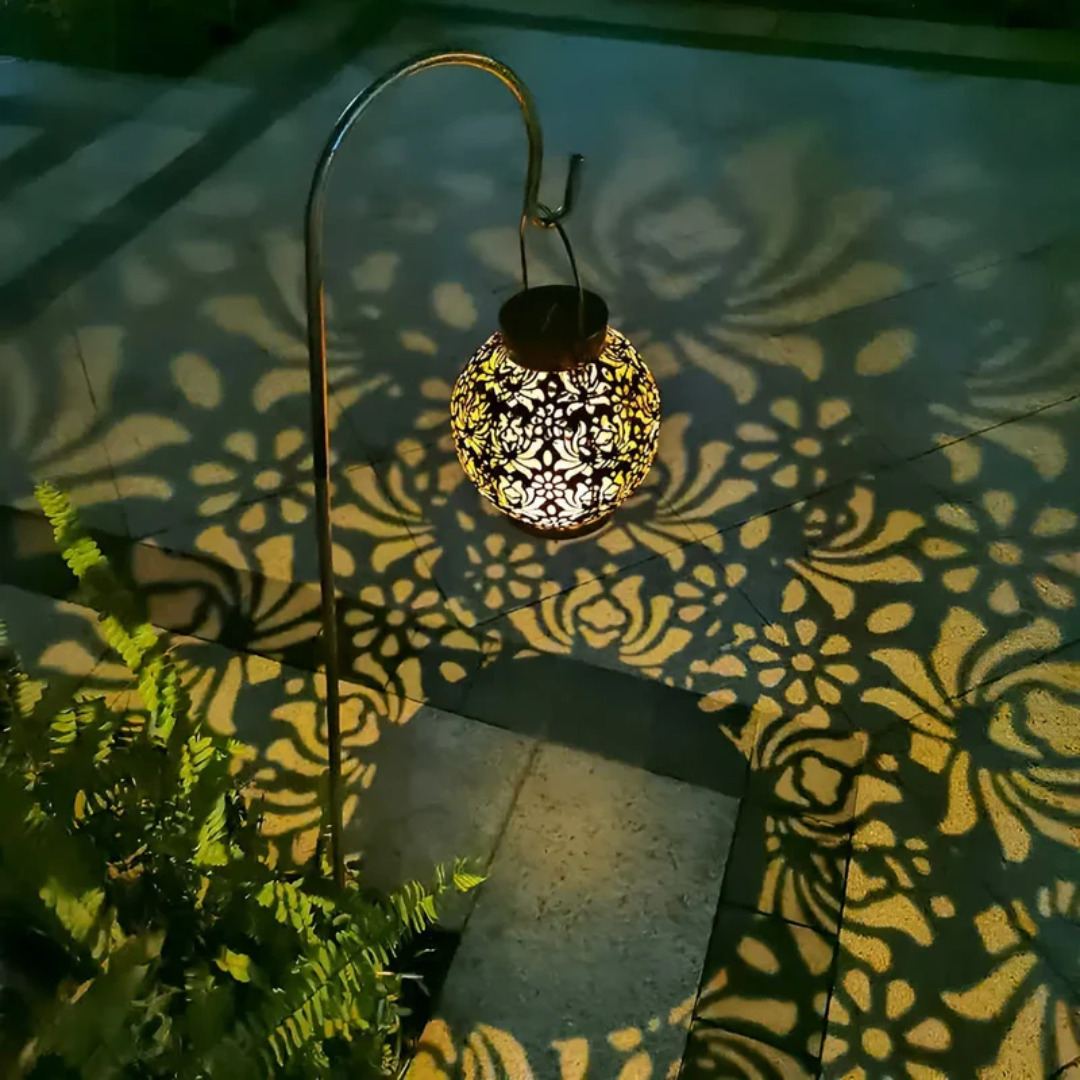 Solarbetriebene Gartenlaterne mit filigranem Muster, warmweißes Licht, dekorative Außenbeleuchtung.