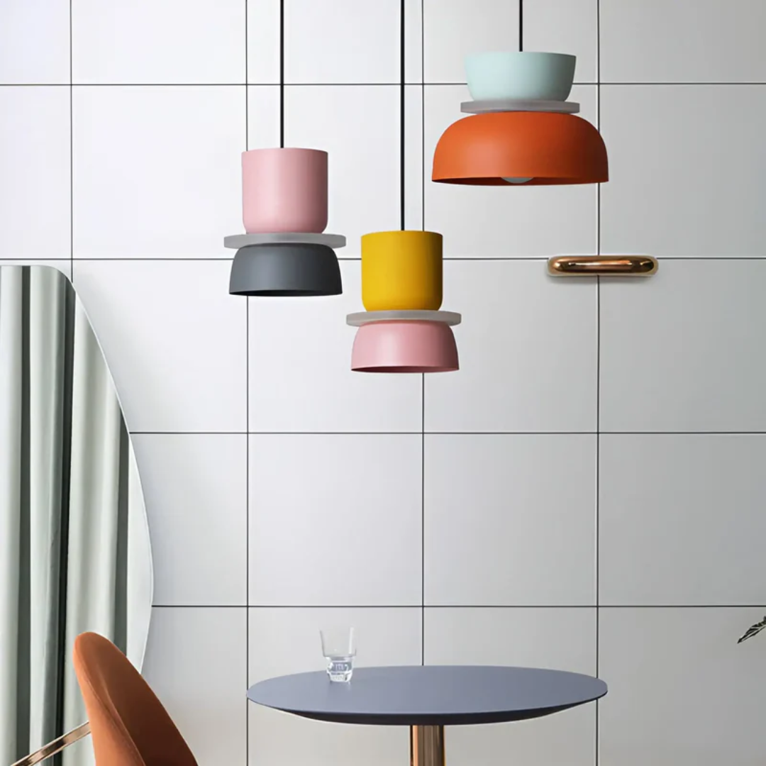 Moderne bunte Hängelampen vor weißer Kachelwand, stilvolle Inneneinrichtung.