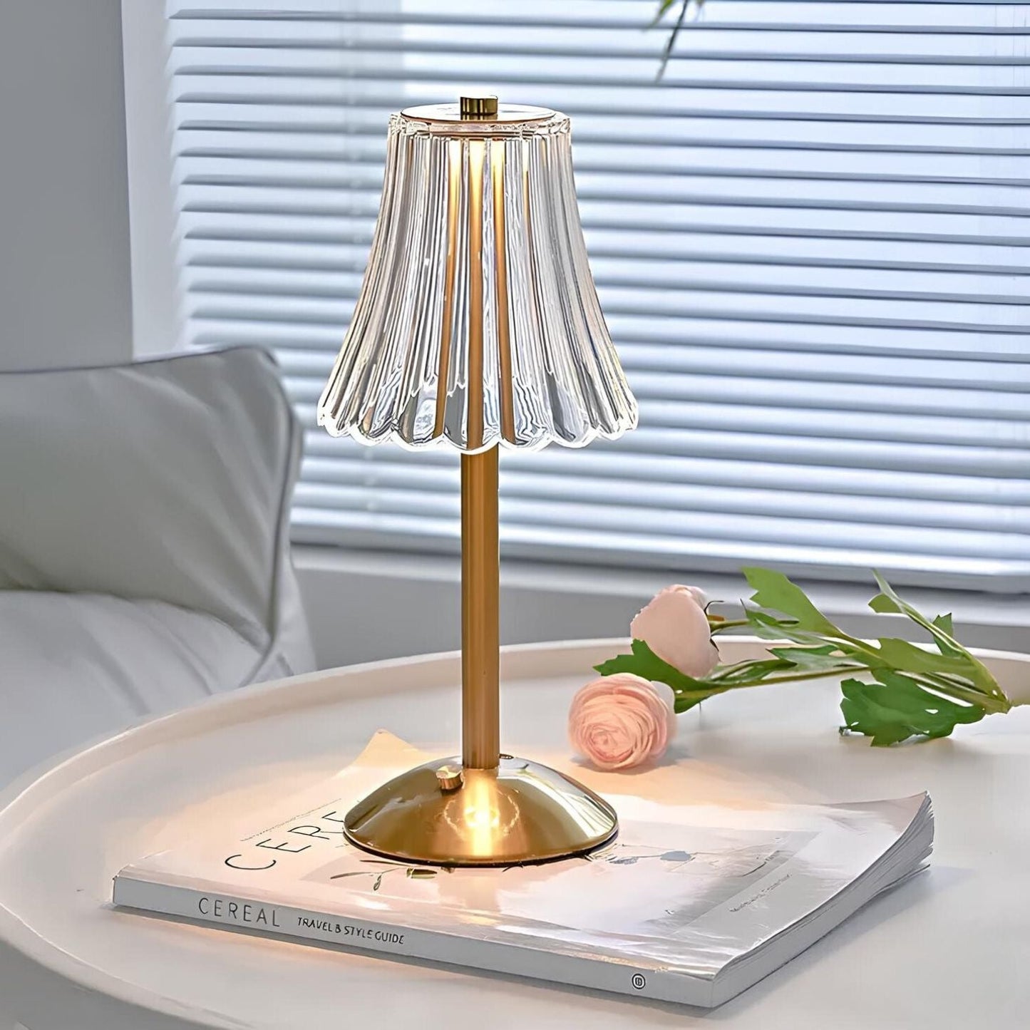 Goldene Tischlampe mit geriffeltem Glasschirm auf weißem Tisch, moderne Inneneinrichtung.