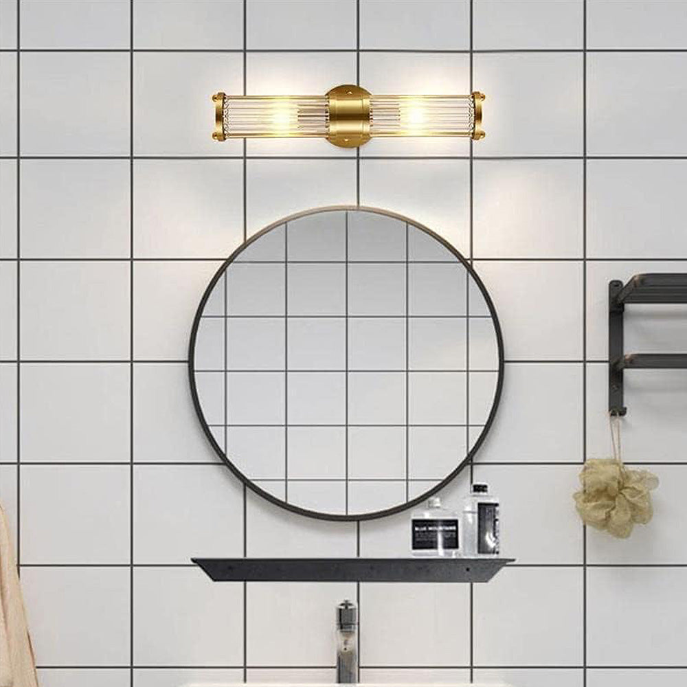 Goldene Wandleuchte über rundem Spiegel im modernen Badezimmer mit Fliesenwand.