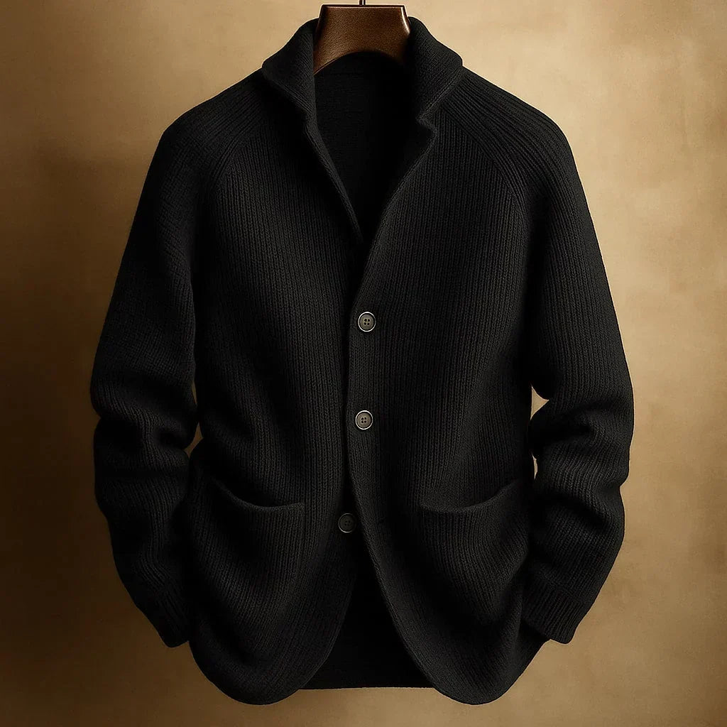 Schwarze Strickjacke mit Rippenstrick, Schalkragen und Knopfleiste, an Holzbügel vor warmem braunem Hintergrund 4