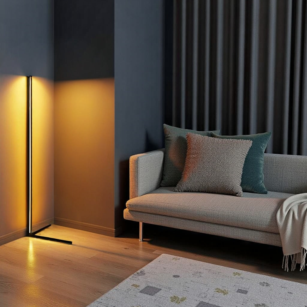 Stehleuchte mit goldenem Licht an dunkelblauer Wand, daneben ein graues Sofa mit Kissen und gemusterter Teppich 11
