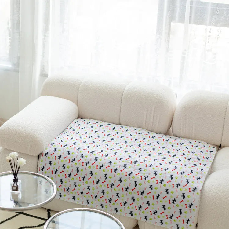 Weiße Couch mit buntem, gemustertem Überwurf im Wohnzimmer, moderne Einrichtung.