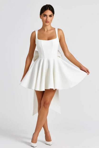 Model in weißem Minikleid mit ausgestelltem Rock, von vorn, hält den Rocksaum seitlich hoch 3